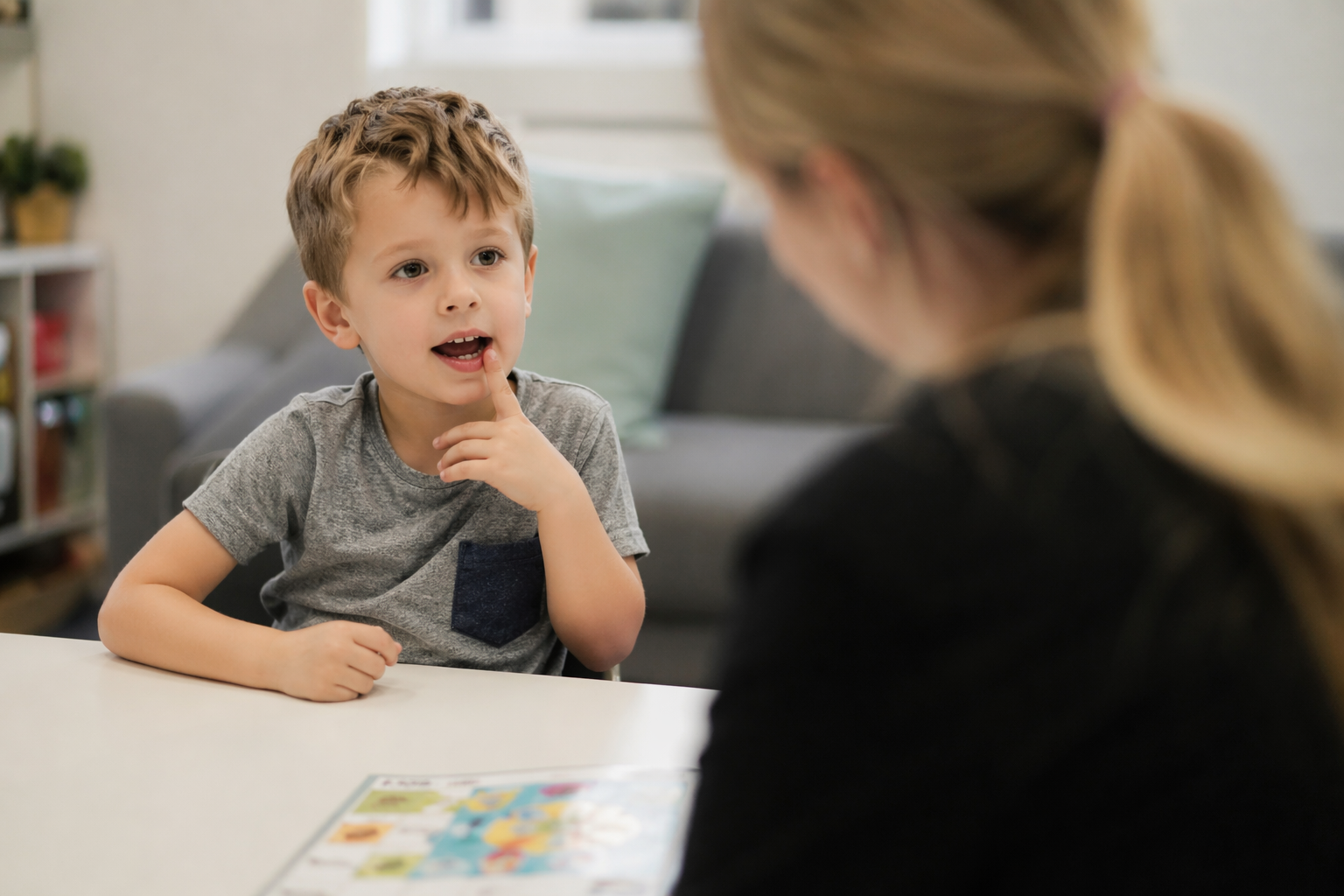 A young boy practising speech sounds with a therapist